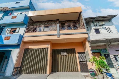 un immeuble d'appartements avec un balcon au-dessus dans l'établissement Hotel O Buduran Homestay Syariah, à Sidoarjo