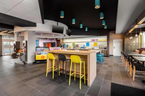a fast food restaurant with yellow chairs and a counter at Tru By Hilton Oshkosh in Oshkosh