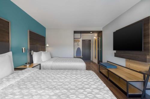 a hotel room with two beds and a flat screen tv at Tru By Hilton Oshkosh in Oshkosh