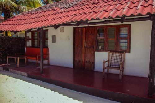 a small house with a red roof at Tikipalmbeachhotel in Paje