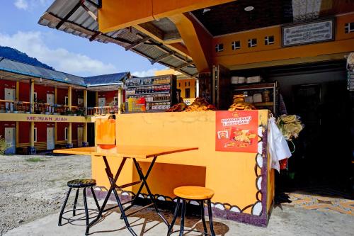 un tavolo e due sgabelli davanti a un negozio di Hotel O Sejolie Sibayak a Berastagi