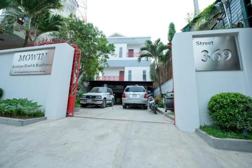 a parking lot with cars parked in front of a building at Mowin Boutique Hotel & Residence in Phnom Penh