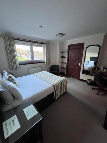 a hotel room with a bed and a mirror at Lochway Hotel in Dumbarton