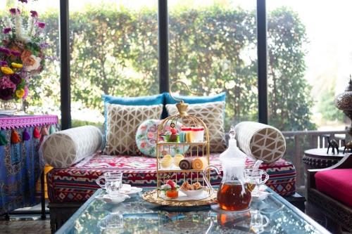 a living room with a table with a tray of food on it at The Grand Morocc Hotel in Mae Rim