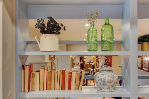 a shelf with books and glass bottles on it at The Gissons Hotel in Exeter