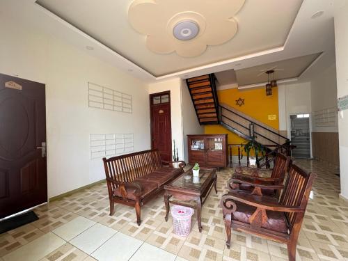 a living room with wooden furniture and a staircase at SPOT ON 1229 Happy Dream Homestay in Da Lat