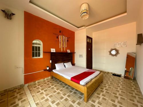 a bedroom with a bed with orange walls at SPOT ON 1229 Happy Dream Homestay in Da Lat