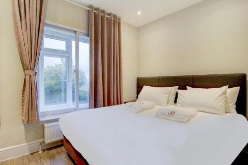 a bedroom with a large white bed with a window at The Gissons Hotel in Exeter