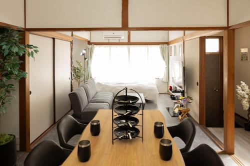 a living room with a table and a couch at 金運の上がる宿 岡山駅徒歩圏内 駐車場無料 最大6名 完全貸切 in Okayama