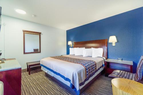 a hotel room with a large bed and a table at Budget Inn Frederick US-183 in Frederick