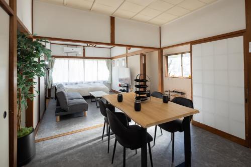 a room with a table and chairs and a living room at 金運の上がる宿 岡山駅徒歩圏内 駐車場無料 最大6名 完全貸切 in Okayama