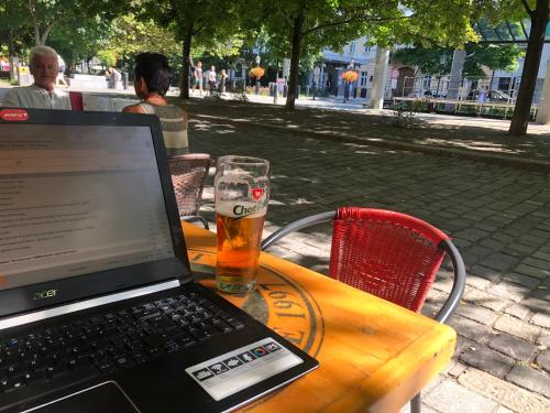 a laptop sitting on a table with a glass of beer at Vibe Loft free drink daily by Zazi in Bratislava