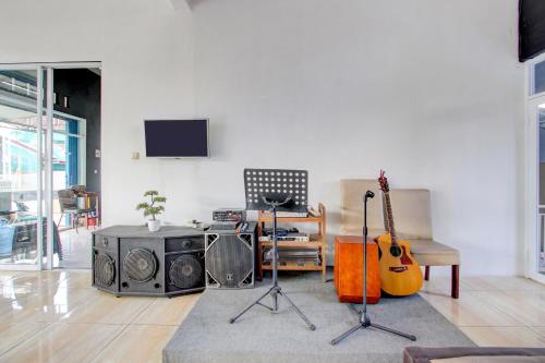 a living room with a guitar and other musical instruments at Hotel O Wonosobo Bunkbed in Wonosobo