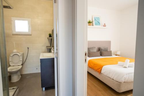 a bedroom with a bed and a toilet and a sink at SEAING HOUSE in Falca