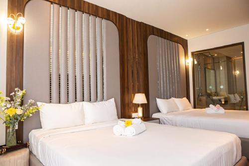a hotel room with two beds with towels on them at Apec Mandala Romantic Mui Ne in Ấp Thiẹn Ái