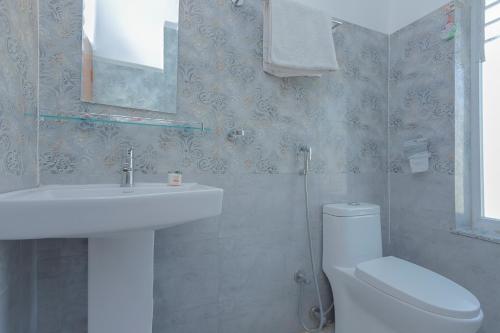 a bathroom with a sink and a toilet and a mirror at OYO 799 Hotel Tik Tok Pvt Ltd. in Kathmandu