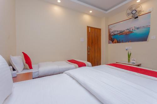 two beds in a bedroom with white walls at OYO 799 Hotel Tik Tok Pvt Ltd. in Kathmandu