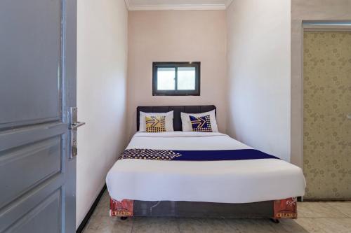 a bed in a small room with a door at Hotel O 3n Homestay Syariah in Sidoarjo
