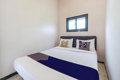 a small bedroom with a white and blue bed at Hotel O 3n Homestay Syariah in Sidoarjo