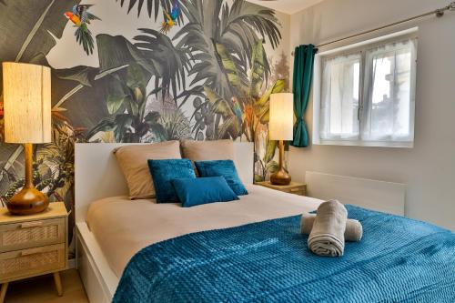 une chambre avec un grand lit avec des oreillers bleus dans l'établissement Jungle Cruise #200m François 1er, à Cognac