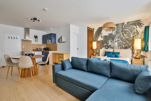 un salon avec un canapé bleu et une chambre dans l'établissement Jungle Cruise #200m François 1er, à Cognac