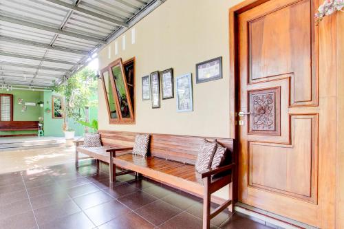 a room with a bench and a wooden door at Hotel O Homestay Koe Syariah in Purwokerto