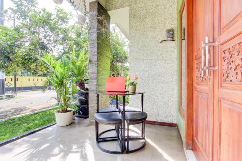 a table and a stool in front of a window at Hotel O Homestay Koe Syariah in Purwokerto