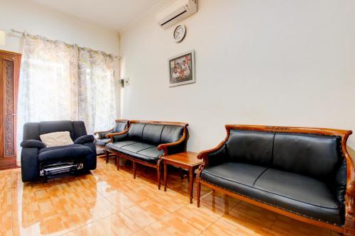 a living room with leather chairs and a couch at Hotel O Homestay Koe Syariah in Purwokerto