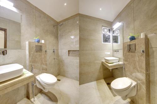 a bathroom with a toilet and a sink and a shower at Hotel International Inn - Near Delhi Airport in New Delhi