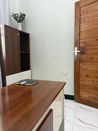 a kitchen with a wooden counter top and a wooden cabinet at MASAI Apartment Goba in Dar es Salaam
