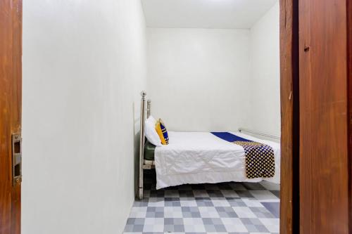 Una cama o camas en una habitación de SPOT ON 93967 Hasna Guest House Syariah