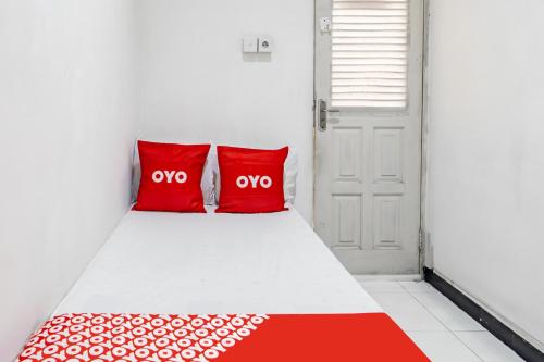 a bedroom with two red pillows on a bed at OYO Life 93977 Suterejo Homestay Syariah in Surabaya