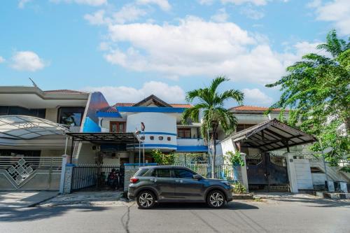 une voiture garée devant une maison dans l'établissement OYO Life 93978 Wisma Homestay Syariah, à Surabaya