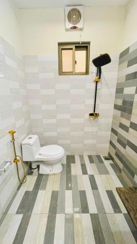 a bathroom with a white toilet in a room at Holiday Guest House Lahore in Lahore