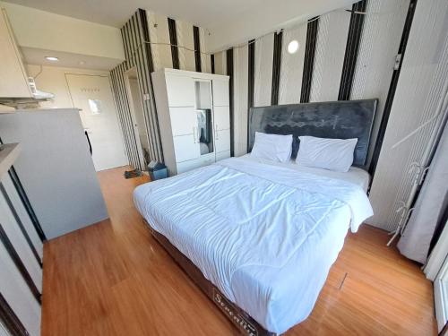 a bedroom with a large bed with white sheets at Hotel O Apartement Sentraland By Helen Mangement in Jaken 1