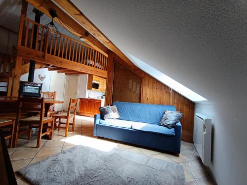 un salon avec un canapé bleu et une table dans l'établissement Résidence Palathium - Grand appartement duplex pour 4 à 6 personnes - Terrasse TROPEZIENNE plein sud - Vue pistes. MAE-8354, à Montgenèvre