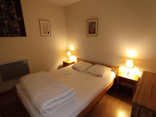 une chambre avec un lit avec deux lampes sur deux tables dans l'établissement Résidence Ferme D'augustin - Batiment D - Appartement 4/6 personnes - Skis aux pieds MAE-9154, à Montgenèvre
