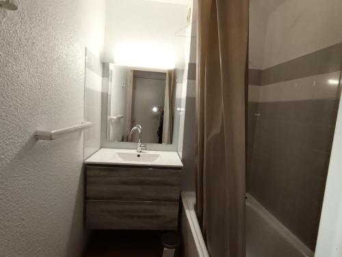 une salle de bain avec un lavabo, un miroir et une baignoire dans l'établissement Résidence Ferme D'augustin - Batiment D - Appartement 4/6 personnes - Skis aux pieds MAE-9154, à Montgenèvre