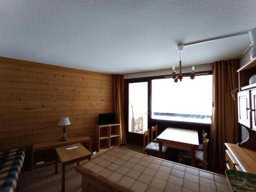 - un salon avec une grande fenêtre et un bureau dans l'établissement Résidence Ferme D'augustin - Batiment F - Appartement 2 pièces 4/6 personnes -Skis aux pieds MAE-9144, à Montgenèvre