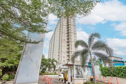 a tall white building with palm trees in front of it at OYO 94010 Victoria Square in Kandang-besar