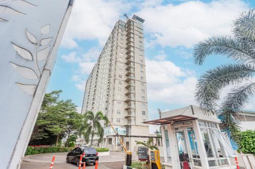 a tall white building with a car parked in front of it at OYO 94010 Victoria Square in Kandang-besar