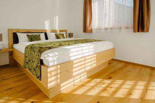 1 dormitorio con 1 cama grande y suelo de madera en Kanis Appartements, en Schoppernau