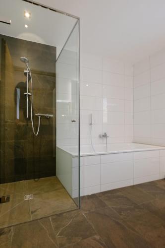 a bathroom with a shower and a bath tub at Kanis Appartements in Schoppernau