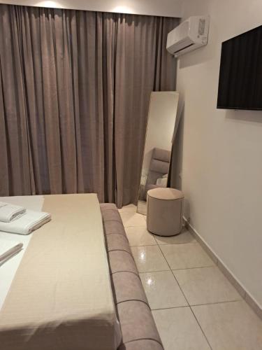 a hotel room with a bed and a chair at Spyridoula Studio 12 in Paleokastritsa