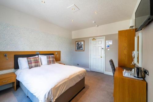 a bedroom with a large bed and a television at OYO The Red Lion Hotel in Luton