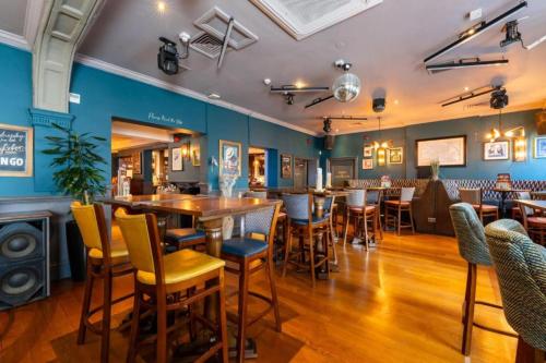 a bar with tables and chairs in a restaurant at OYO The Red Lion Hotel in Luton
