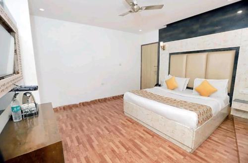 a bedroom with a large bed with orange pillows at Almora Hotel Delhi International Airport With - Free Airport Pickup in New Delhi