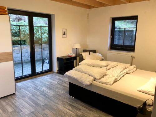 a bedroom with a bed and a large window at Rabenlay in Oberneisen