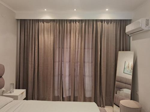 a bedroom with a bed and a window with curtains at Spyridoula Studio 11 in Paleokastritsa