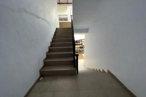 a staircase in a white wall with a stair case at Hotel O Kos Rian in Sungguminasa